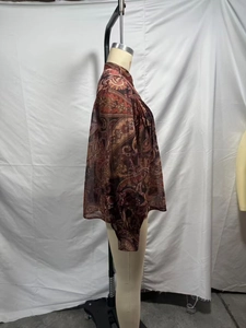 Detail of bohemian paisley chiffon blouse featuring ruffled cuffs and intricate lace trim
