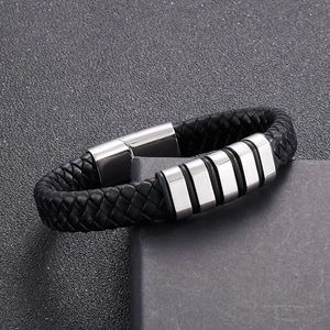 Détail d'un bracelet en cuir tressé noir avec anneaux en acier inoxydable sur un coffret