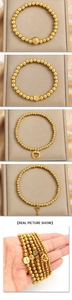 Detail view of four 18K gold-plated bead bracelets with lion, star, heart, and key charms