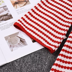 Gros plan détaillé d'une manche de robe en maille rayée rouge et blanc sur un magazine