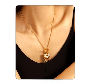 Detail of gold fluid heart pendant with crystals and OT buckle on a chic necklace