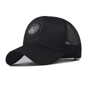 Detailed macro view of black trucker hat showing breathable mesh and textured fabric