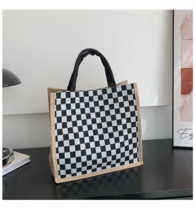 Detailed close-up of checkered canvas tote bag with woven jute trim and sturdy black handles