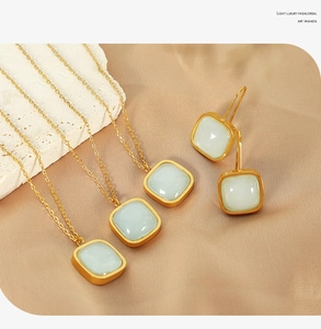 Detail view of elegant light green square gemstone necklace and drop earring set in gold