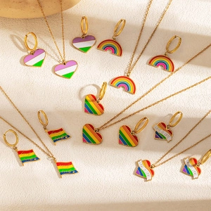 Flat lay of gold rainbow jewelry sets featuring colorful heart and bridge pendants