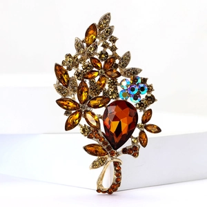 Detailed view of luxury gold-tone floral brooch with amber crystals and rhinestones