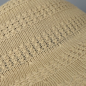 Macro shot showing the breathable knitted texture and hollow pattern of the beige bucket hat