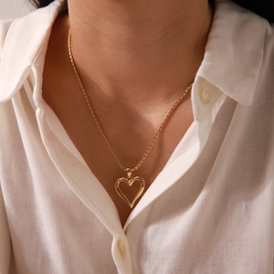 Elegant gold hollow heart pendant necklace in stainless steel shown on model