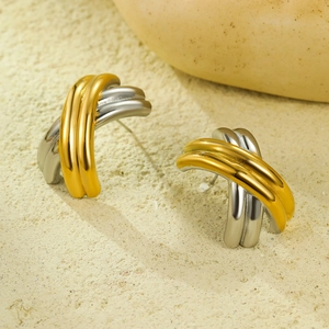 Macro shot of two-tone C-shape interlocking earrings in gold and silver finish