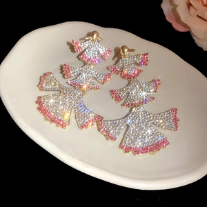 Macro detail of luxury fan-shaped earrings with sparkling pink and white rhinestones