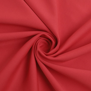 Gros plan détaillé du tissu rouge de la robe avec drapé en spirale et texture fine