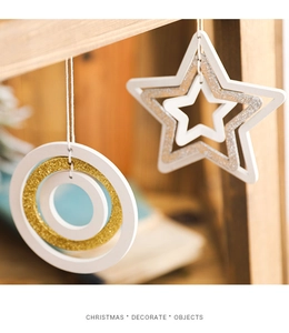 Detailed close-up of white wooden star and ring Christmas ornaments with metallic glitter