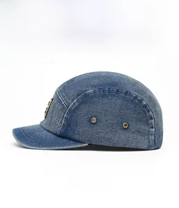 Side view of dark blue denim camper hat showing metal eyelets and contrast stitching