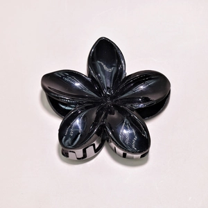 Glossy black plumeria flower hair claw clip with smooth finish and secure grip detail