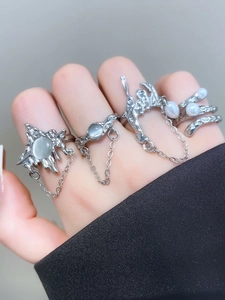 Detailed view of silver bow ring set with grey cat eye stones and pearls on hand