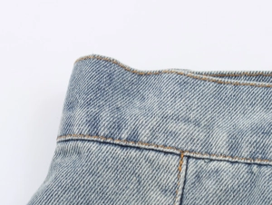 Close-up of light blue denim midi skirt waist with detailed contrast stitching and texture