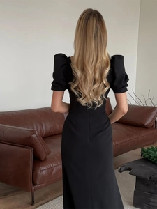 Back view of a slim black dress with puff sleeves and elegant square neckline detail