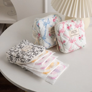 Detailed macro view of quilted cotton makeup bags with floral patterns and bow accents