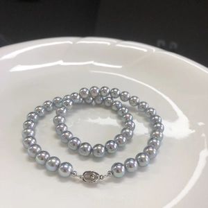 Lustrous blue-grey Akoya style pearl necklace with S925 sterling silver clasp on white plate