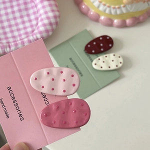 Detail of colorful oval polka dot hair clips set on handmade packaging cards