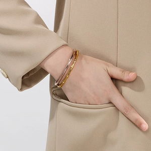 Close-up of a model wearing 18K gold plated bamboo-style bangles in rose gold and gold finish