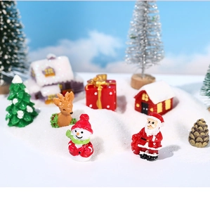 Close-up of resin Christmas miniatures with Santa, snowman and reindeer on snow