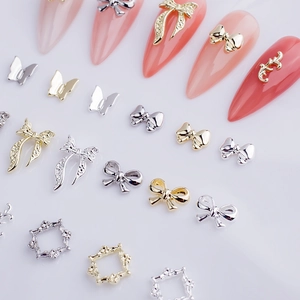 Detail view of gold and silver alloy 3D ribbon bow nail art charms set in various styles