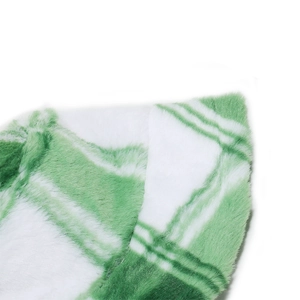 Close-up of green and white checkered faux rabbit fur fabric on a warm winter hat
