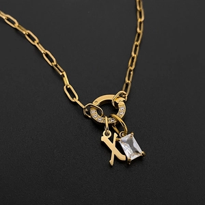 Detailed view of 14K gold plated paperclip necklace with letter X and crystal pendant