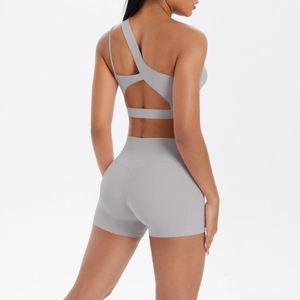 Detail view of back cross straps on light gray yoga bra and high waist fitness shorts