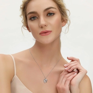 Silver mother and child necklace with openwork heart pendant on female model