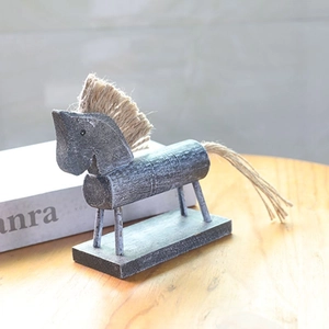 Dettaglio di statuetta cavallo in legno vintage con criniera in fibra e finitura grigia