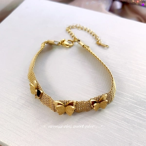 Gold butterfly charm bracelet with textured layered chains and lobster clasp