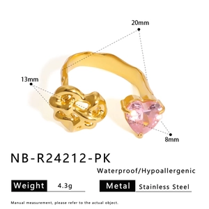 Detail of stainless steel ring featuring gold lava texture and pink heart-shaped gemstone