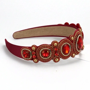 Detailed macro view of baroque red velvet headband with luxurious gemstones and gold beads