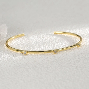 Minimalist gold plated adjustable open bangle featuring three sparkling round zircons