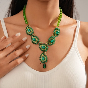 Detailed view of green crystal teardrop pendant necklace on model with bohemian beads