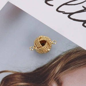 Close-up of golden braided knot bead for jewelry DIY crafts showing metal texture
