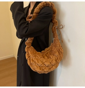 Close-up of caramel velvet quilted crescent bag showing soft texture and crossbody strap
