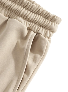 Detail of beige linen blend pants featuring elastic drawstring waist and side pockets
