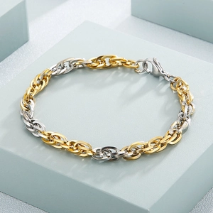Polished two-tone gold and silver titanium chain bracelet on a blue geometric stone