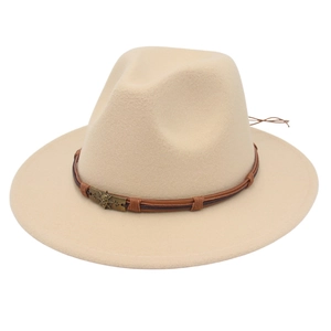 Macro detail of beige wool fedora hat featuring brown leather band and skull emblem