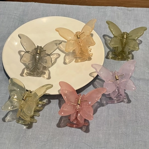 Flat lay of six translucent jelly butterfly hair claws in various vibrant colors