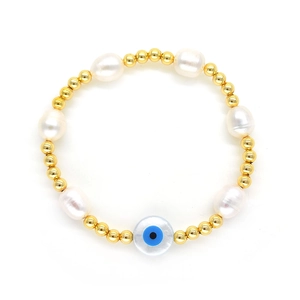 Macro view of baroque pearl bracelet featuring a blue evil eye bead and golden spheres