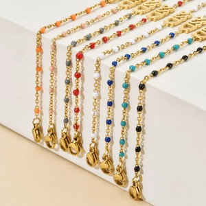 Colorful beaded stainless steel bracelets with KISS pendant on white geometric blocks