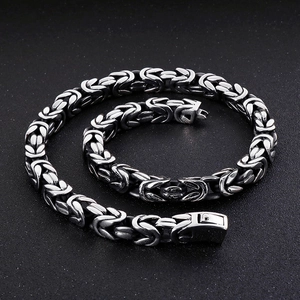 Polished silver stainless steel Byzantine chain bracelet with square clasp on black texture