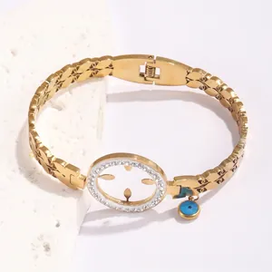 Gold-plated hollow bangle with pave zircon circle and blue evil eye charm accent
