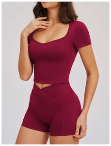 Close-up detail of burgundy high-waisted yoga shorts with side pocket and cross-waist design