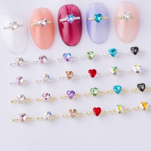 Macro shot of colorful heart-shaped crystals in gold and silver nail art bases