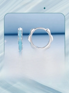 Close-up of S925 silver hoop earrings with blue enamel flower petal design